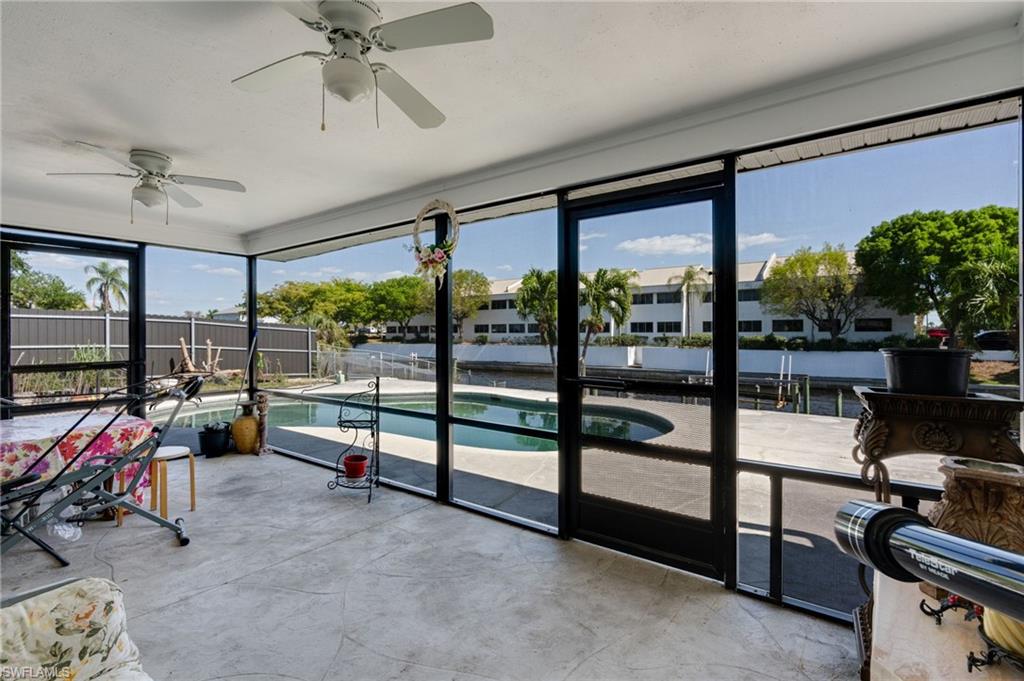 Screened patio with a concrete floor, two ceiling fans, and direct access to an in-ground swimming pool