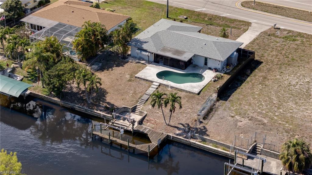 Waterfront property featuring a private boat dock, concrete seawall, and direct water access