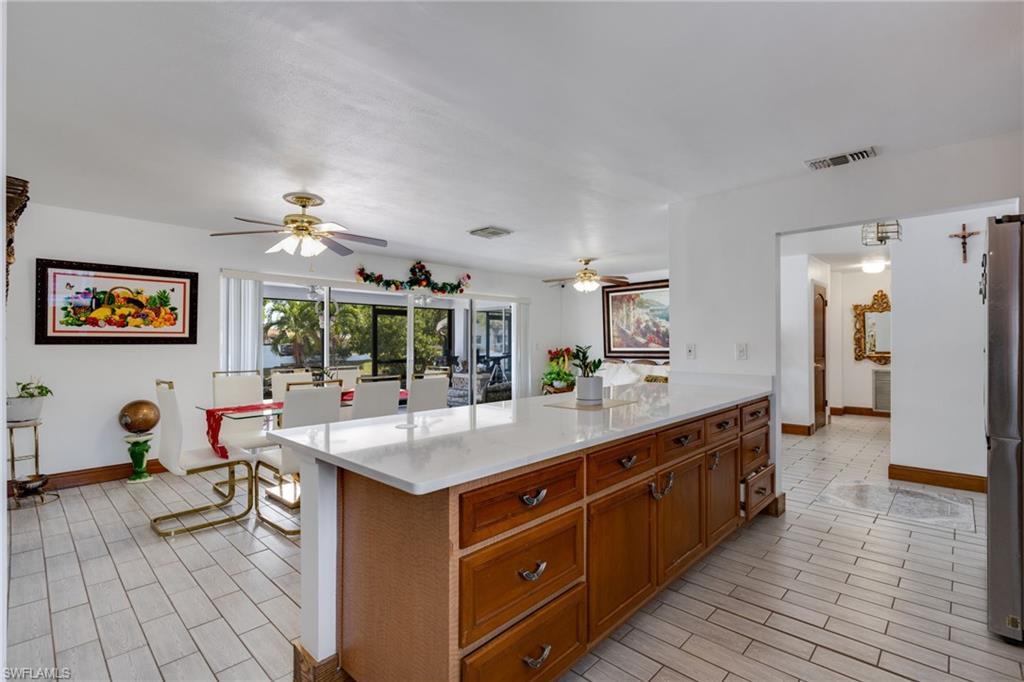 Spacious kitchen island featuring wood cabinetry and a light-toned countertop