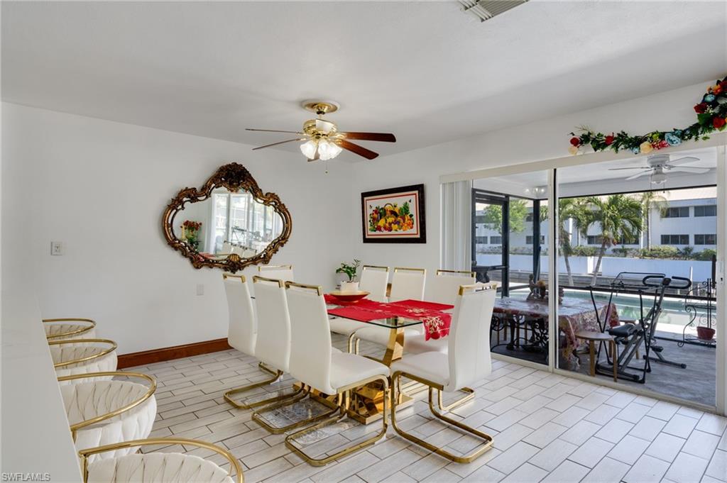 Tiled flooring extends into a space featuring a ceiling fan and a gold-framed mirror