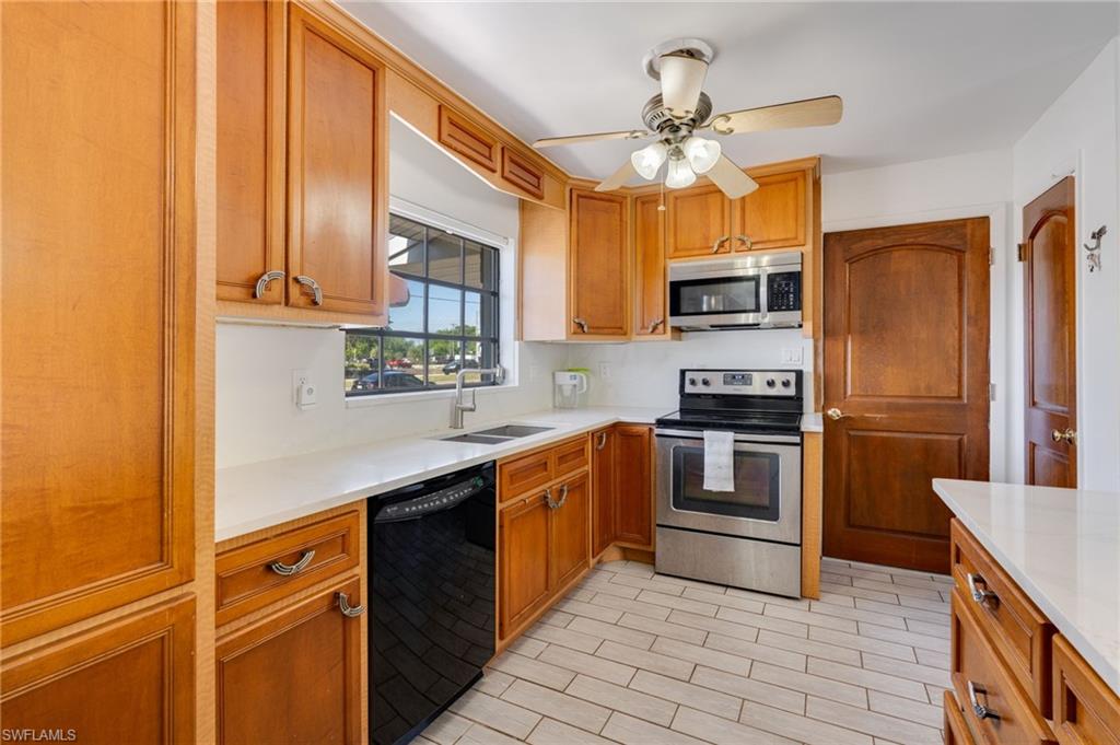 Kitchen featuring wood cabinetry, light countertops, and stainless steel appliances