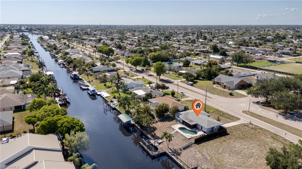 Waterfront property featuring a private boat dock, in-ground swimming pool, and a spacious paved driveway