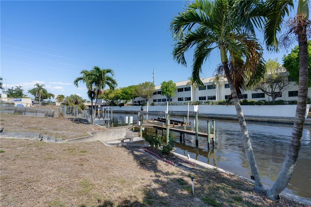 Waterfront property featuring a private dock with pilings and an elevated boat lift