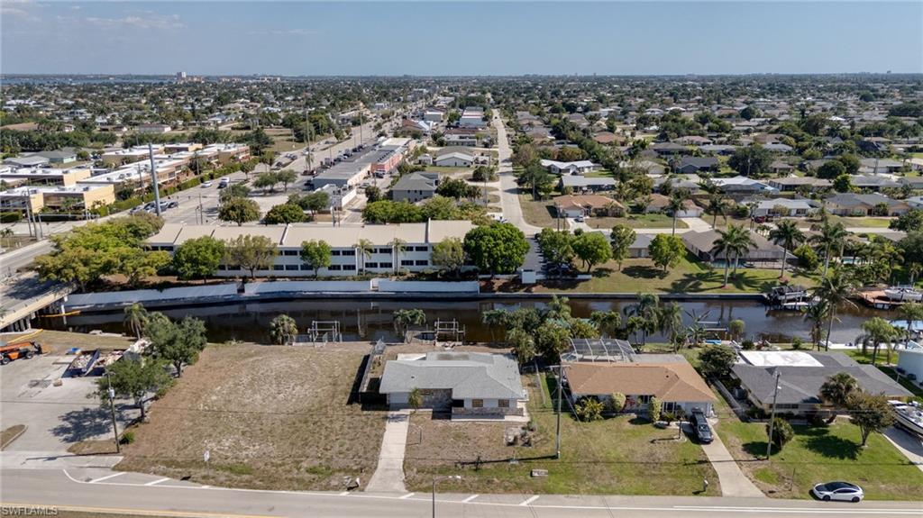 Waterfront property featuring a canal, private dock structures, and surrounding mature palm trees