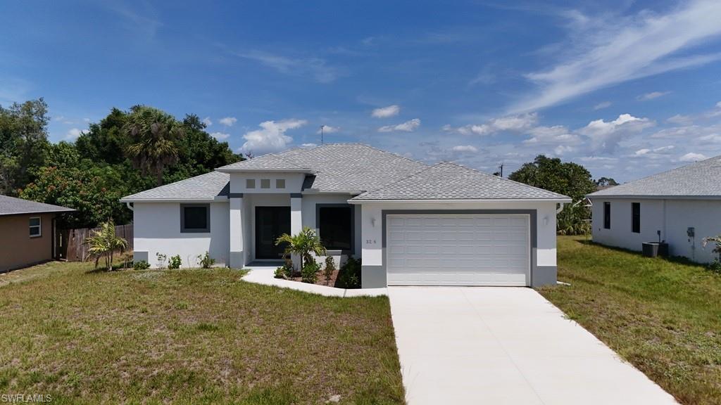 Contemporary single-story residence featuring a two-car garage, concrete driveway, and a light gray shingle roof