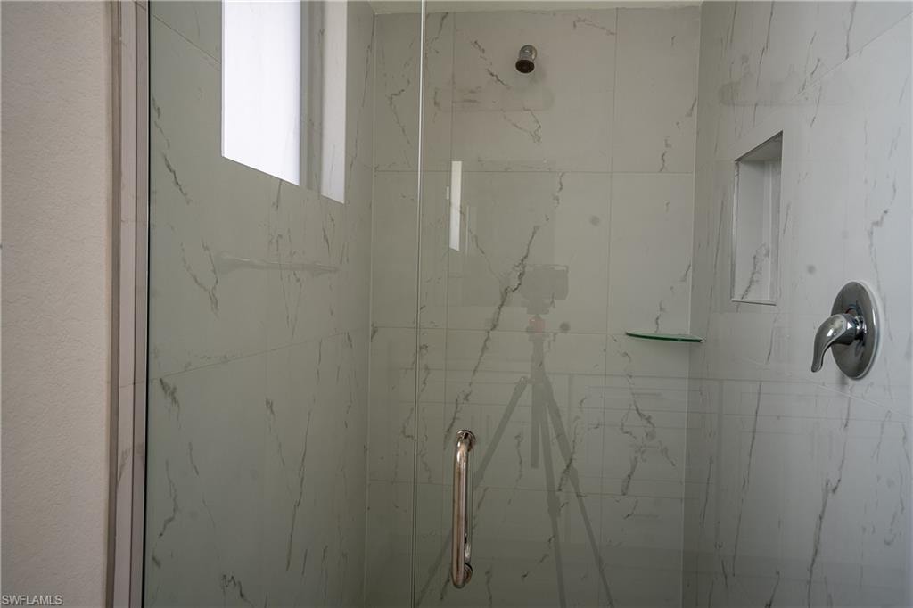 Shower enclosure with clear glass paneling and a polished chrome handle
