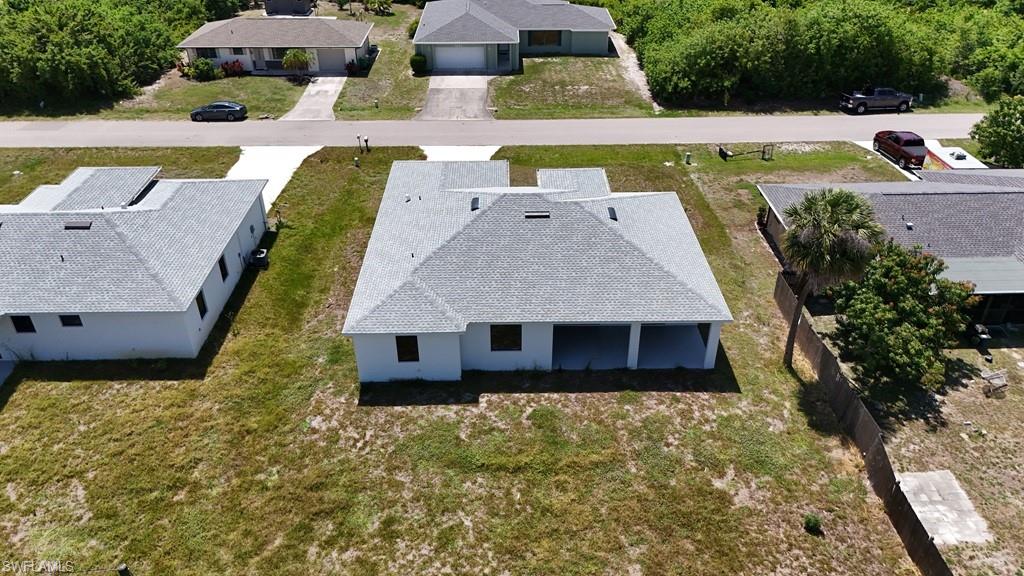 New construction residence featuring a light gray shingle roof, white exterior walls, and a covered patio