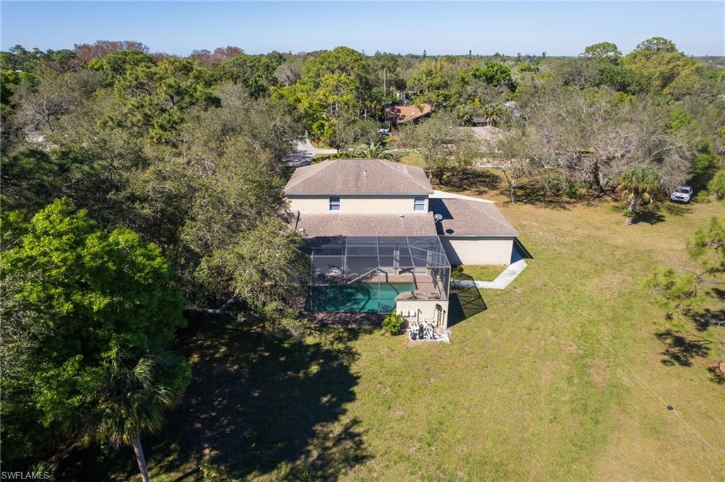 Two-story residence featuring a screened-in swimming pool and an expansive green lawn