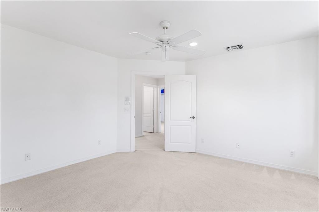 Carpeted room with a ceiling fan, recessed lighting, and a white paneled door