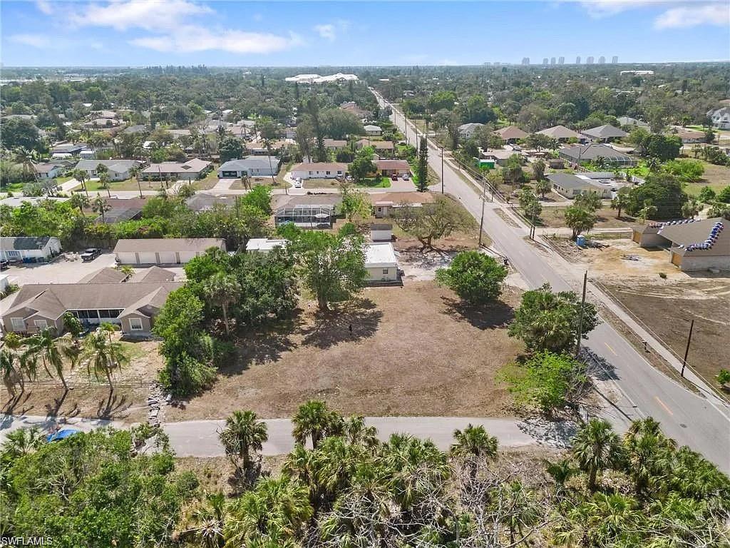 Expansive cleared lot featuring mature palm trees and direct road access