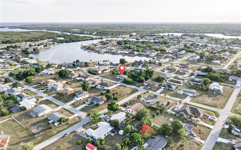 Aerial perspective showcasing a residential neighborhood with a prominent waterway