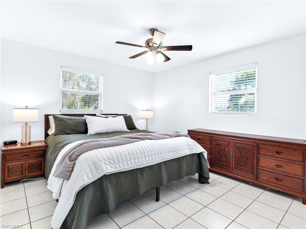 Spacious room featuring neutral white walls and light-toned tile flooring
