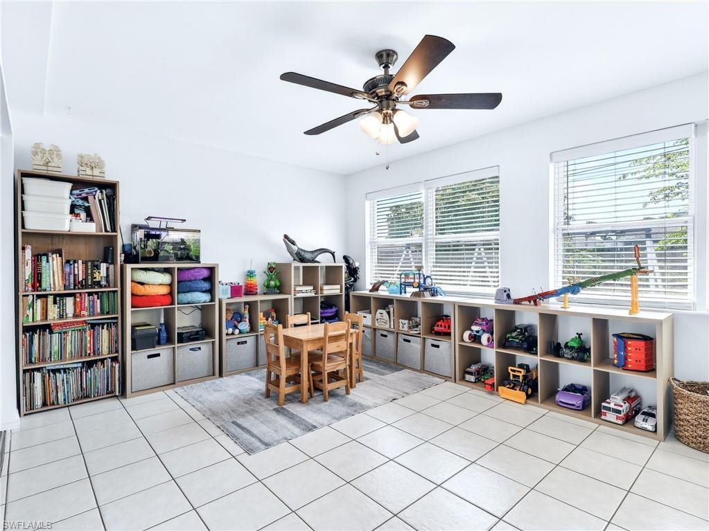 Spacious room featuring light-colored tile flooring and abundant natural light from multiple windows