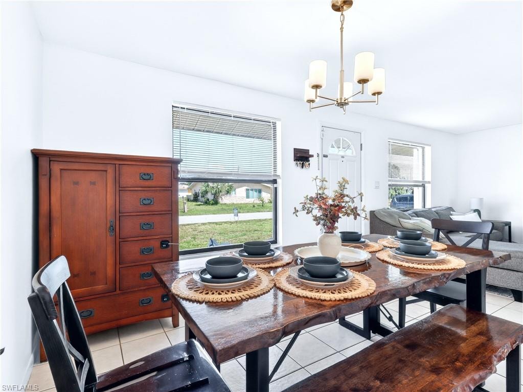 Dining area with tile flooring and a multi-light chandelier