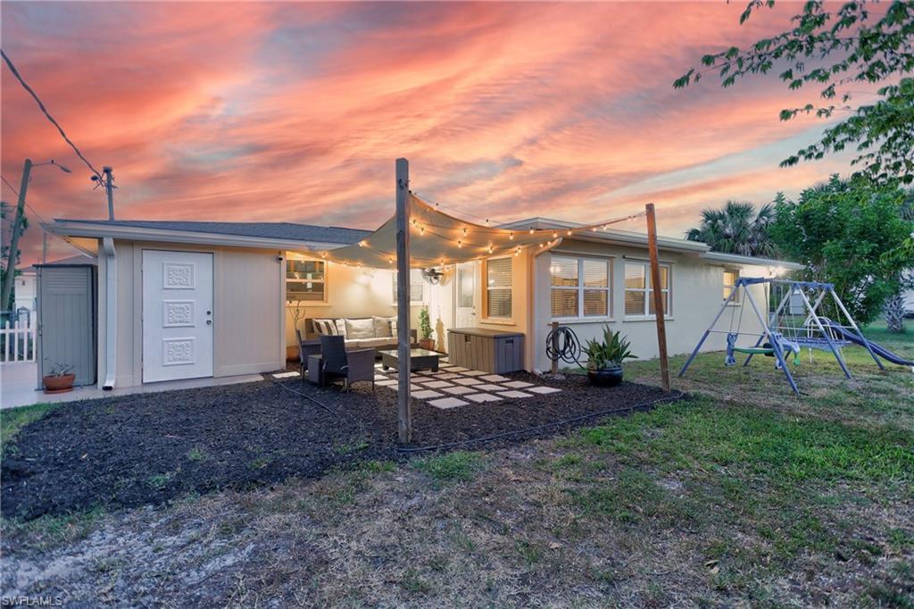 Rear exterior featuring a covered patio, string lighting, and a square paver patio