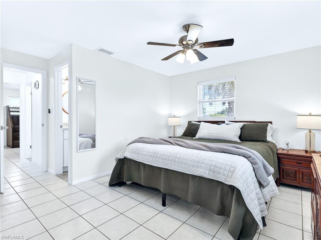 Bedroom featuring white square tile flooring, a ceiling fan with integrated lighting, a window providing natural light, and a white wall finish