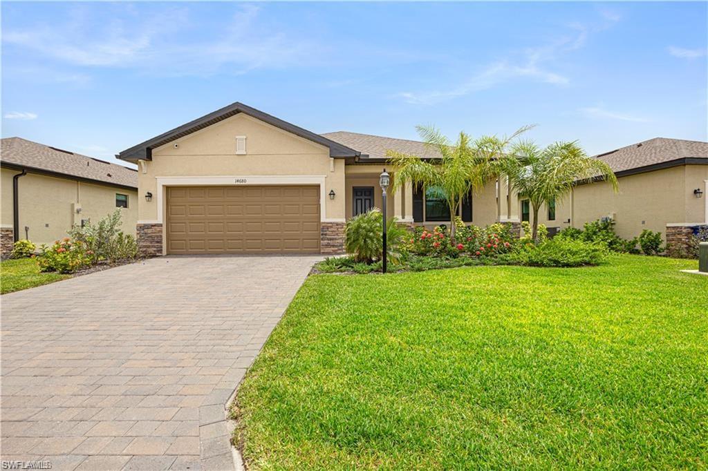 Contemporary stucco and stone-accented exterior with a paver driveway