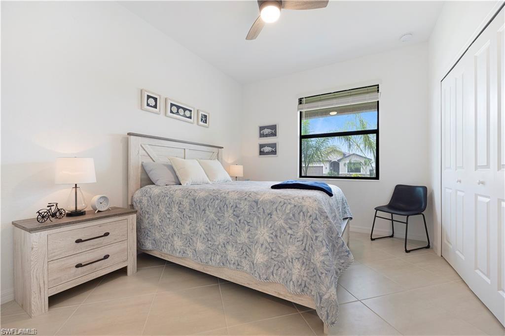 Bedroom featuring light-toned tile flooring, a window with blinds, and white walls