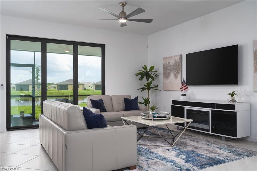 Spacious living area featuring large format tile flooring, a modern ceiling fan, and expansive sliding glass doors