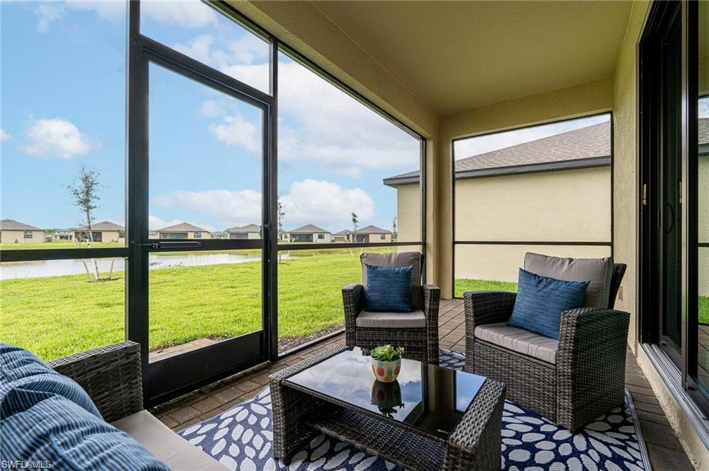 Screened outdoor patio featuring a water view, paver flooring, and direct exterior access