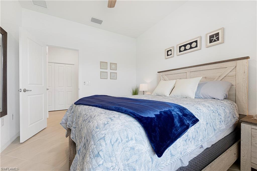 Vaulted ceiling bedroom featuring wood-finish flooring, a white paneled door, and a built-in closet with bifold doors