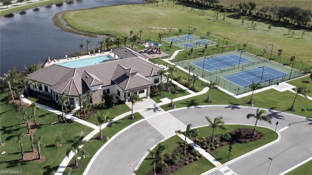 Community clubhouse featuring a swimming pool, multiple tennis courts, pickleball courts, and a playground