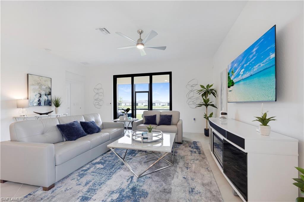 Spacious living area featuring white walls and tile flooring