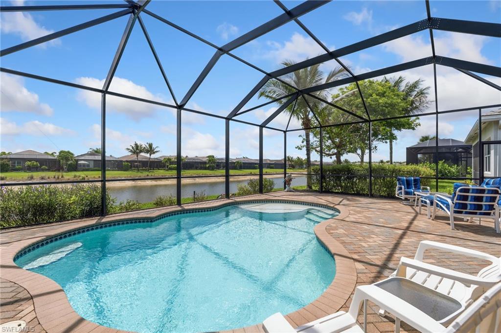 Lanai features heated pool with sun shelf, lake view, and cage