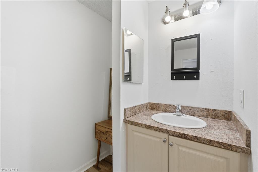 Bathroom vanity featuring a laminate countertop, integrated sink, and base cabinetry