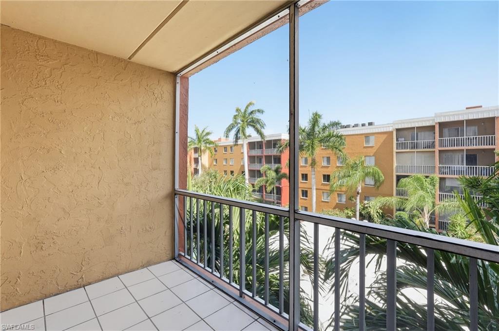 Screened balcony with textured stucco walls, white tile flooring, and metal railing