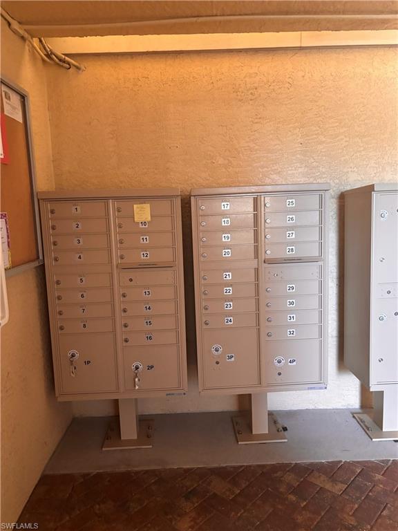 Community mailboxes featuring individual parcel lockers and a herringbone brick-patterned walkway