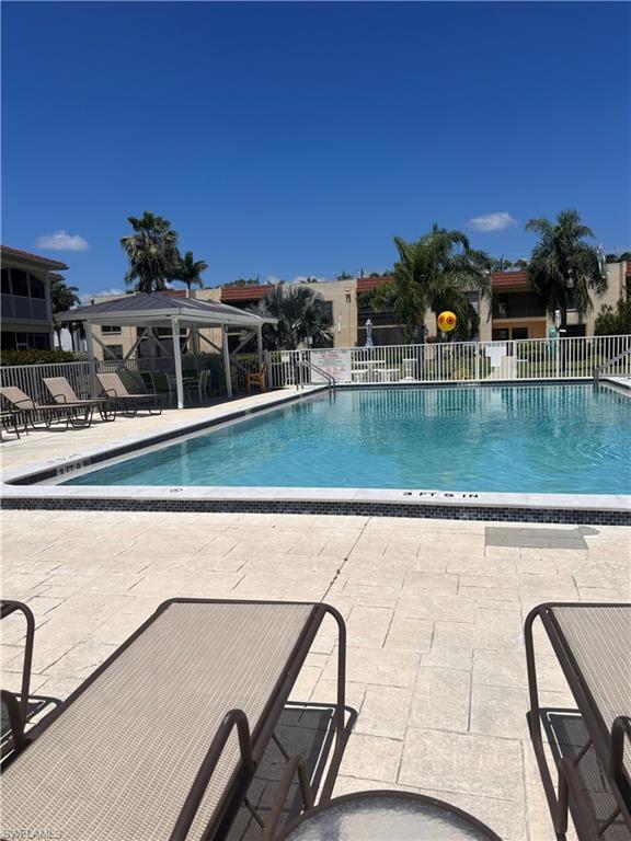 Swimming pool with a tile border and light-colored paver decking