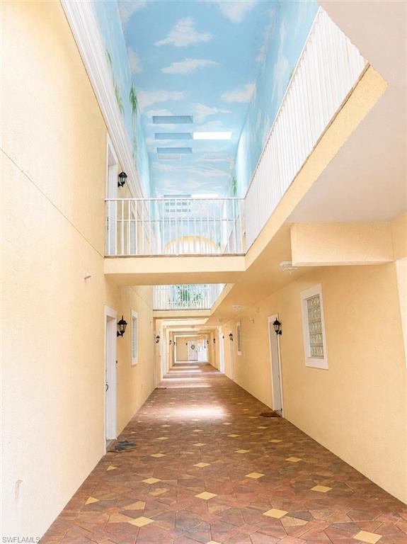 Corridor with patterned tile flooring and light-colored stucco walls