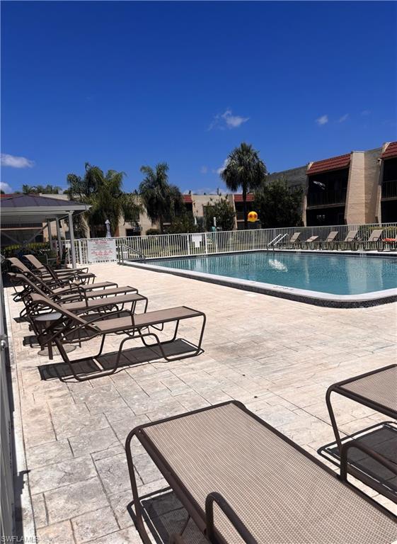 Outdoor swimming pool featuring a perimeter fence and an adjacent paved deck