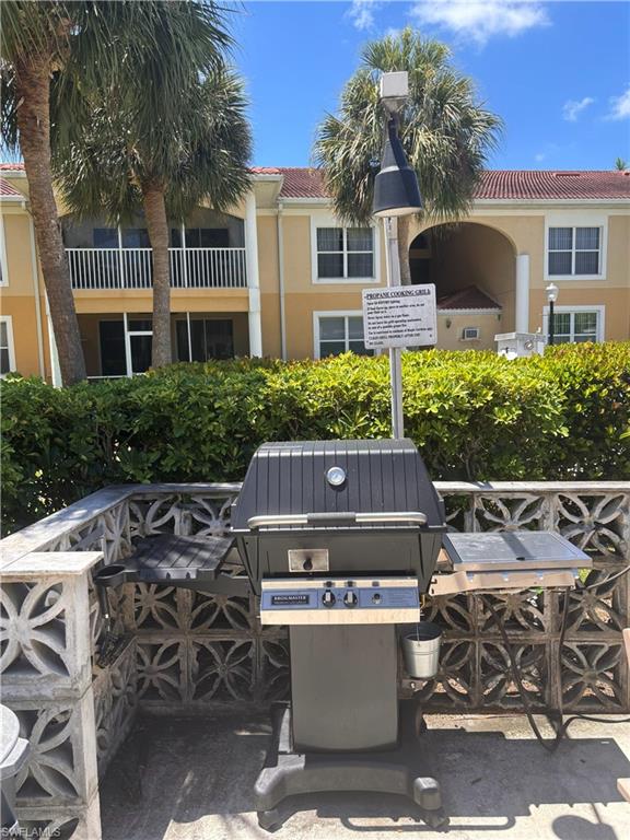 Outdoor grilling station featuring a built-in gas grill, decorative concrete block enclosure, and integrated side shelves