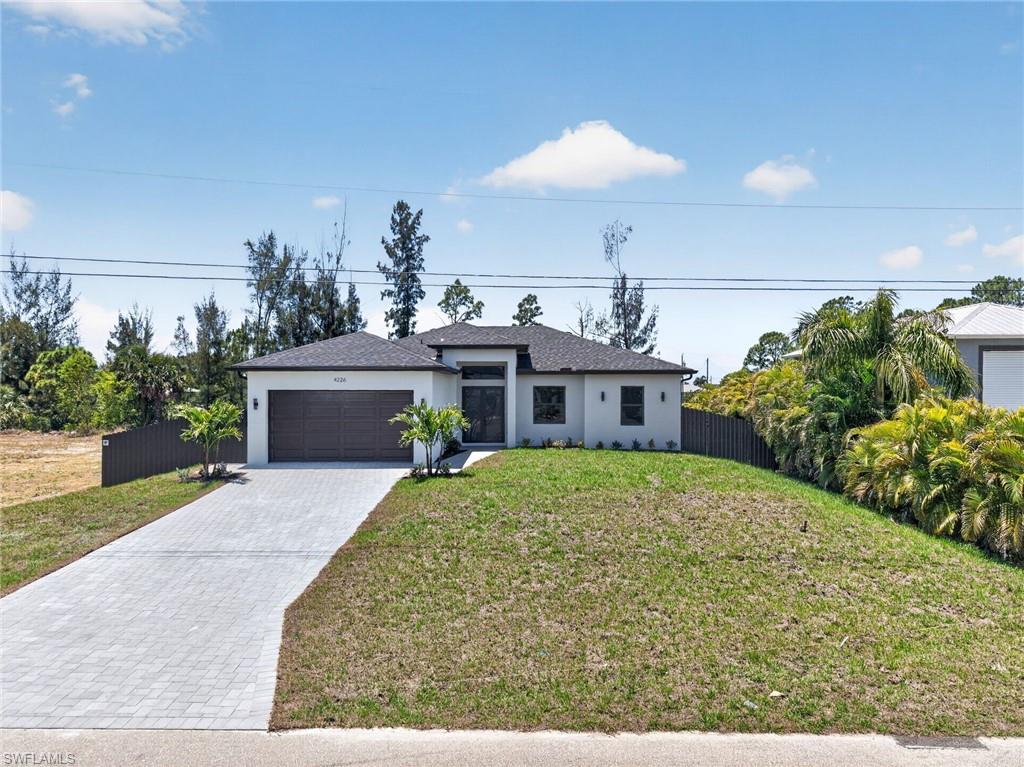 Contemporary stucco exterior featuring a dark tile roof and integrated two-car garage