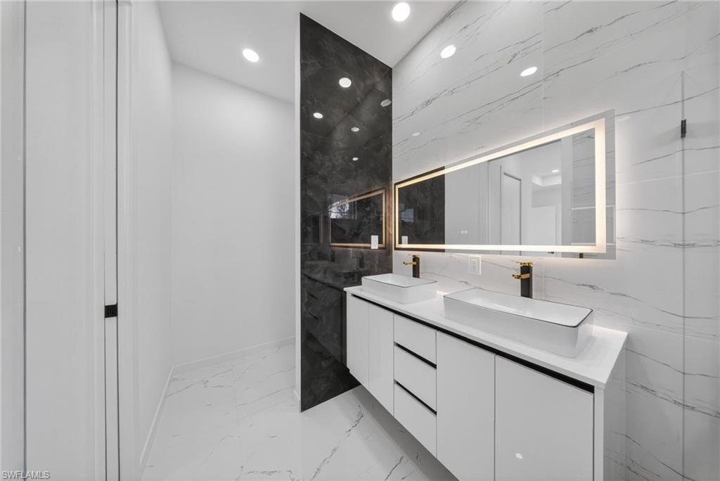 Dual vessel sinks atop a floating vanity with integrated storage