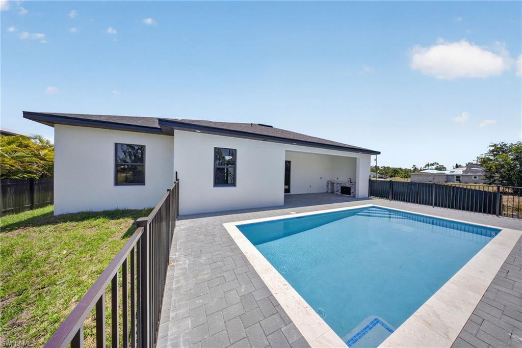 Rectangular swimming pool with light blue interior finish and light-colored coping