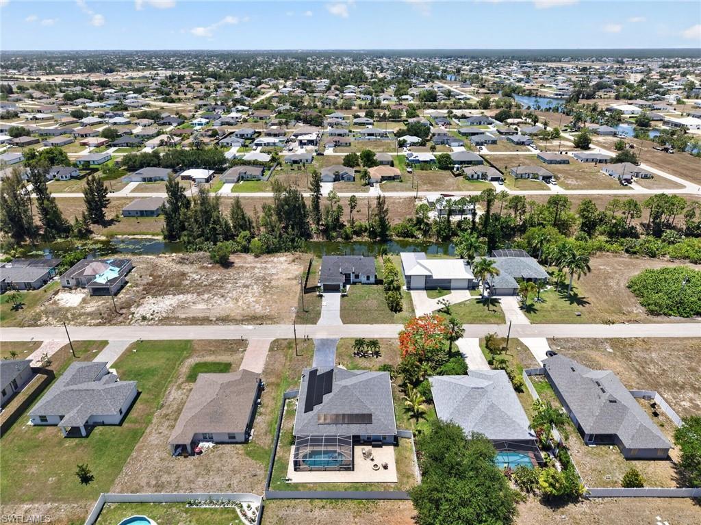 Aerial perspective showcasing a residential neighborhood with single-story homes, many featuring private swimming pools