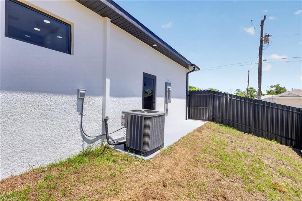 Exterior features a white stucco finish and dark-framed windows