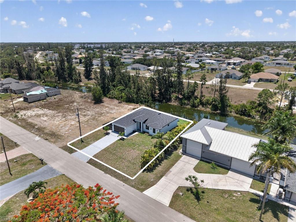 Single-story residence featuring an attached garage, a paved driveway, and a manicured lawn