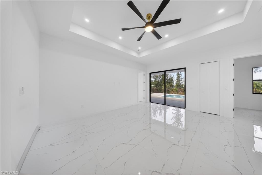 Spacious interior with high ceilings, recessed lighting, and a modern ceiling fan