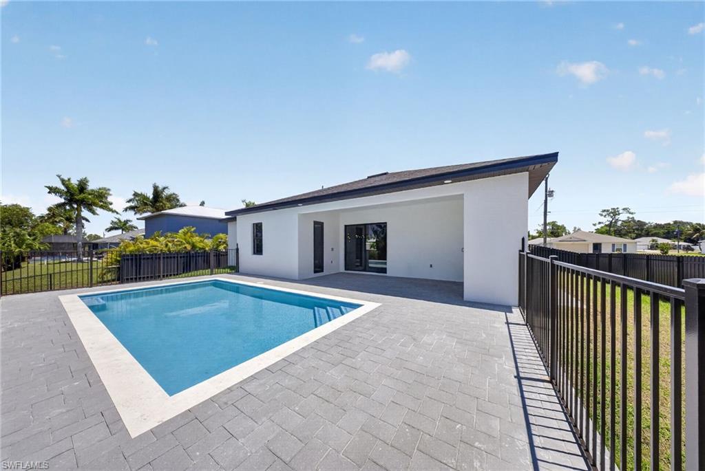 Outdoor pool area featuring a rectangular pool with light blue interior and white coping
