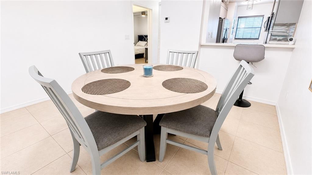 White-painted walls and light tile flooring create an open dining area