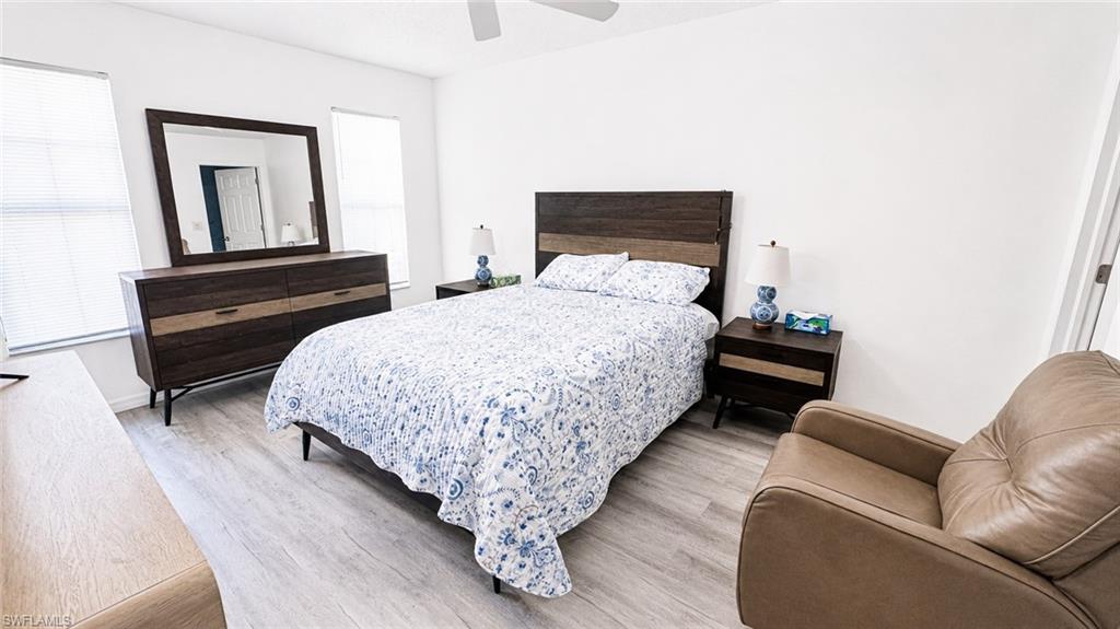 Bright bedroom featuring wood-finish flooring and white walls