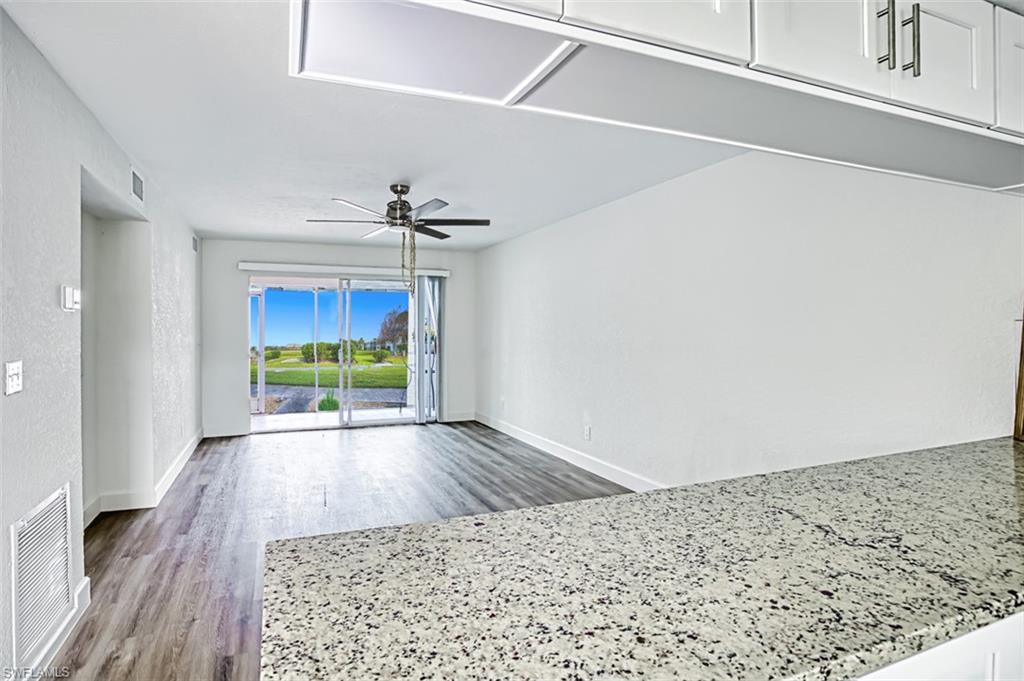 View of living room with entertainment alcove. Granite counters & Luxury Vinyl flooring & Garden view