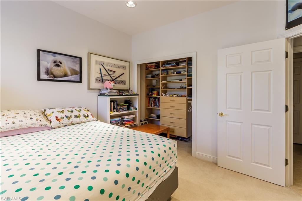 Bedroom featuring light colored carpet and a closet