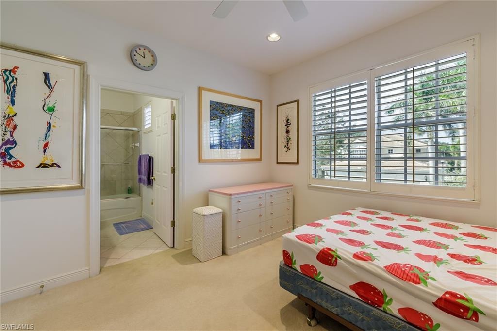 Bedroom featuring ensuite bathroom, light colored carpet, and ceiling fan