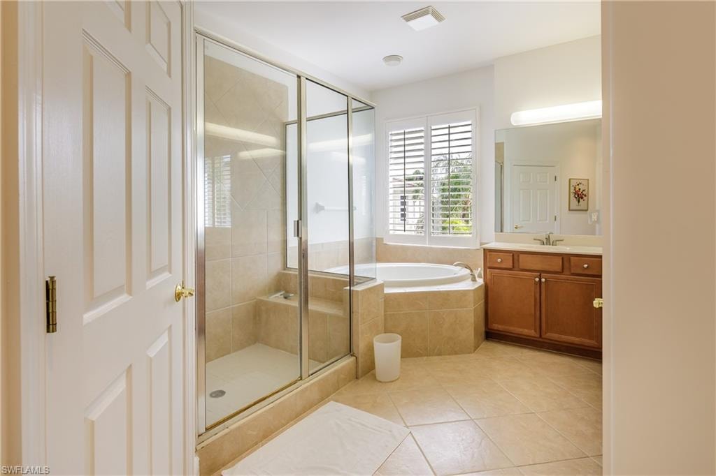 Bathroom with tile patterned floors, independent shower and bath, and vanity
