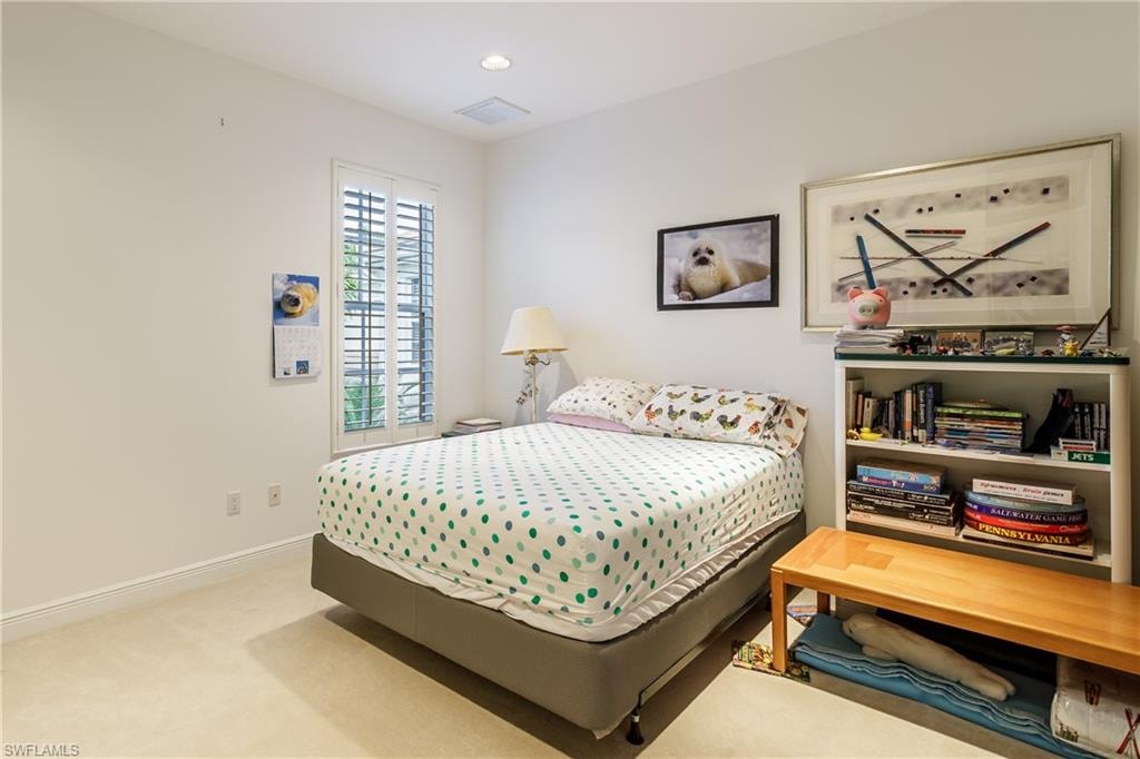 Bedroom featuring light colored carpet